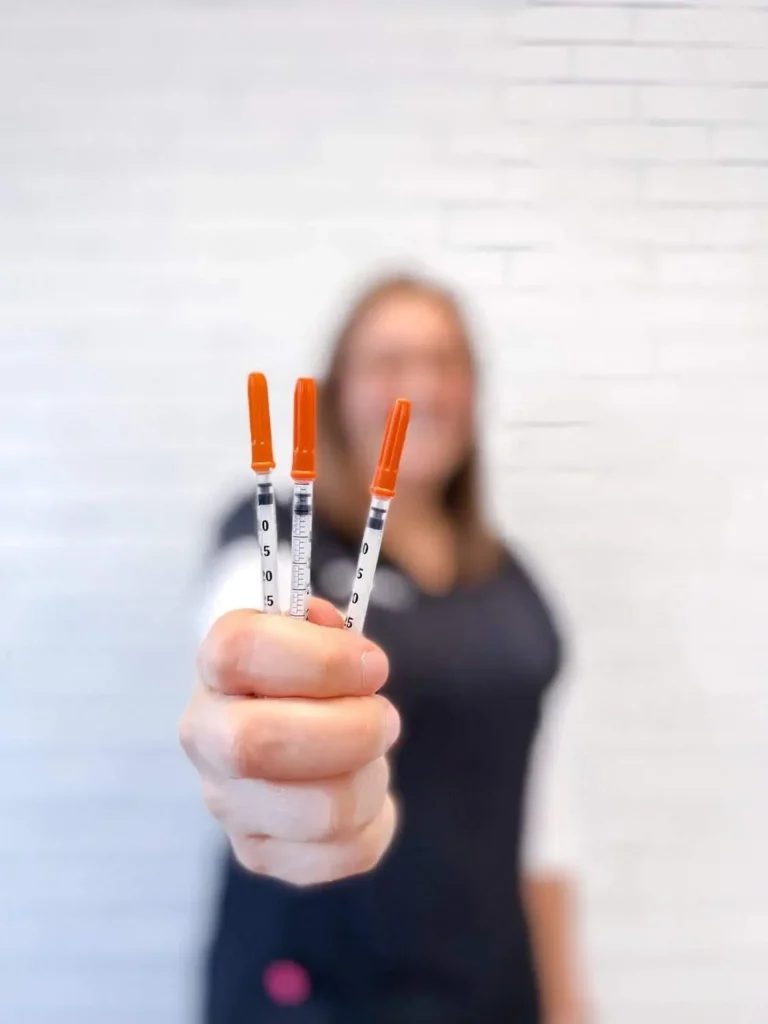 Hand holding three syringes of Dysport, ready for injections in Provo, UT.