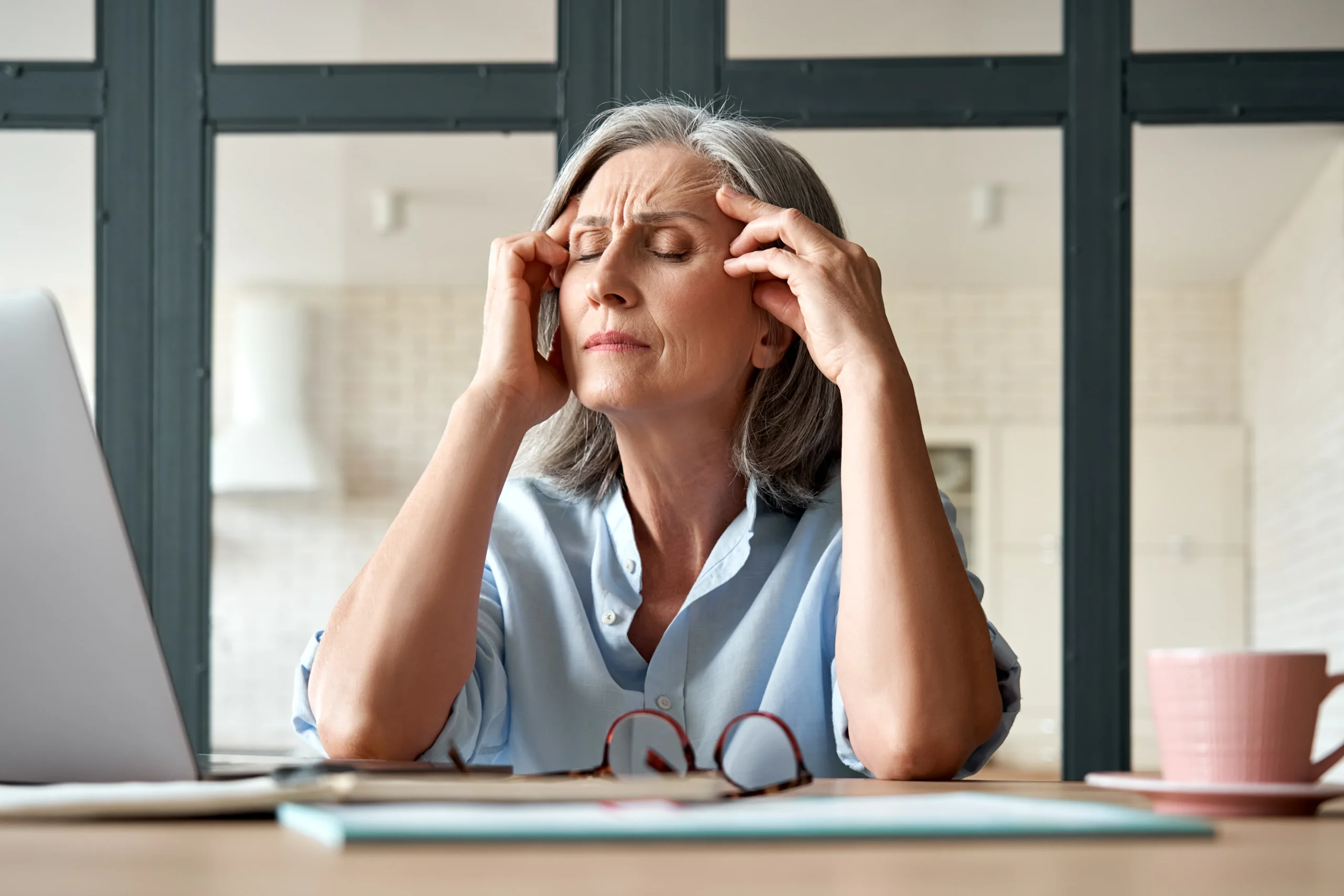 Woman experiencing perimenopause and menopause symptoms such as headaches and fatigue, treated at Optimal Health Family Practice & Medspa