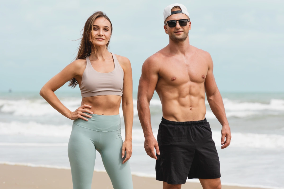 A fit couple standing on a beach